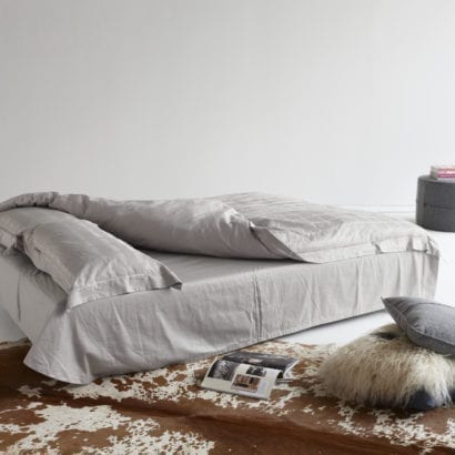 grey bed, rug and ottoman