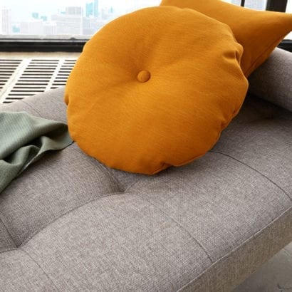 grey daybed with orange cushions